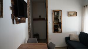 a living room with a couch and a table and a mirror at Lomb Lak Vendégház in Kozármisleny