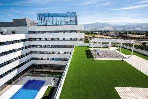 a building with a green lawn on the roof at Living Experience Granada in Granada