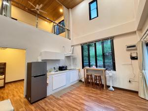 an open kitchen with a refrigerator and a table at Naruemon in Ban Madua Wan