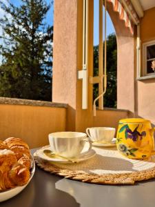 a table with coffee cups and croissants on it at Faggi & Quiet in Mandello del Lario
