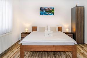 a bedroom with a large bed with white sheets at House Mila in Korenica