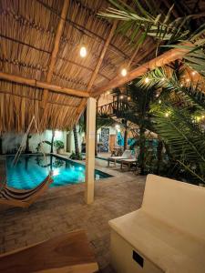 a resort with a pool and a hammock in a room at Nuevo NAYAL in Las Peñitas