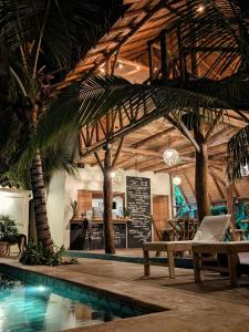 a resort with a swimming pool and palm trees at Nuevo NAYAL in Las Peñitas