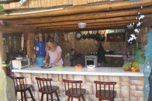a woman standing in a kitchen preparing food at Hotel Viejamar con Cocina compartida in Puerto López