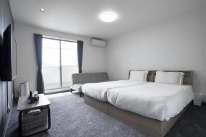 a hotel room with a large bed and a window at Laon Inn Miyakojima in Miyako-jima +19 photos