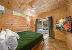 a bedroom with a bed and a flat screen tv at Hickory Hideaway Dollywood, Island, LeConte in Pigeon Forge