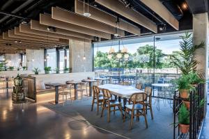 a restaurant with tables and chairs and a large window at Living Experience Granada in Granada