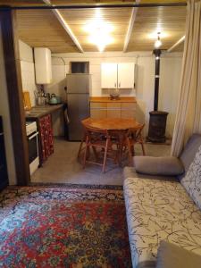 a kitchen with a wooden table and a kitchen with a couch at Gîte nature sous les châtaigniers in Zonza