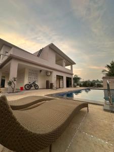 a villa with a swimming pool and a house at Moksha farms -3bhk private villa with pool and nature in Pālghar