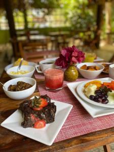 a wooden table with plates of food on it at Pousada Águas de Tamandaré in Tamandaré