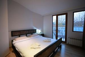 a bedroom with a large bed and a balcony at Hotel Nicolo in Tbilisi City
