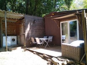a patio with a table and a washing machine at Gîte nature sous les châtaigniers in Zonza