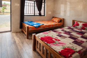 a bedroom with two beds and a bed and a window at Manan Beach Resort in Malpe
