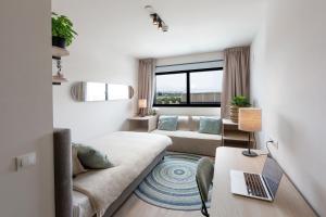 a living room with a couch and a laptop on a table at Living Experience Granada in Granada +44 photos
