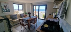 a living room with a table and a couch at MaKarLi Blu in St. Helena Bay