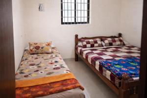 a bedroom with two beds and a pillow in it at Manan Beach Resort in Malpe +20 photos