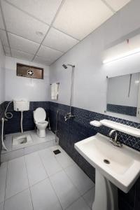 a bathroom with a toilet and a sink and a mirror at Hotel Noor Sky in Islamabad