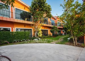 an orange apartment building with a round driveway at Sata House Boutique Resort in Nakhon Ratchasima