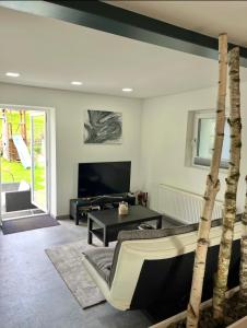 a living room with a tv and a tree at Molers in Stühlingen