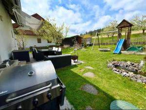 a backyard with a barbecue and a playground at Molers in Stühlingen