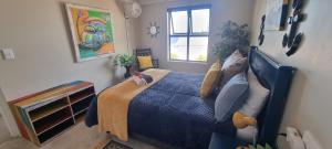 a bedroom with a blue bed and a window at MaKarLi Blu in St. Helena Bay