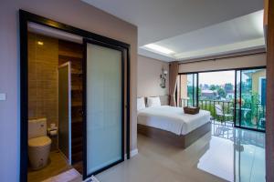 1 dormitorio con 1 cama y balcón en Sata House Boutique Resort, en Nakhon Ratchasima