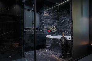 a black bathroom with a shower and a tub at Suite 202 in Mâcon