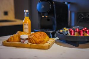 a table with a plate of croissants and a loaf of bread at Suite 202 in Mâcon