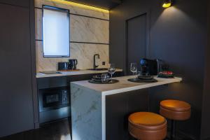 a kitchen with a counter with two stools and a sink at Suite 202 in Mâcon +23 photos