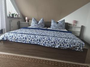 a bedroom with a blue and white bed with pillows at Hoernchens-Ferienwohnung in Neuenkirchen