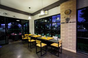 a dining room with tables and chairs and windows at Sata House Boutique Resort in Nakhon Ratchasima +21 photos