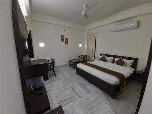 a hotel room with a large bed and a desk at Hotel Aravali Hills View in Kuchāman City