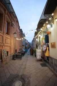 an alley with lights and benches on a city street at Hotel Nicolo in Tbilisi City +18 photos