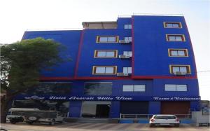 a blue building with cars parked in front of it at Hotel Aravali Hills View in Kuchāman City