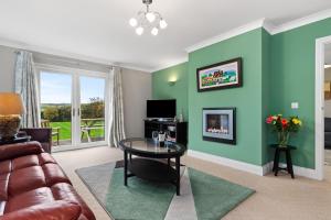 a living room with a couch and a table at Llais Y Mor - large holiday home close to the beach - sleeps 8 in Carmarthen
