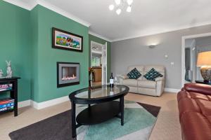 a living room with a table and a couch at Llais Y Mor - large holiday home close to the beach - sleeps 8 in Carmarthen +15 photos