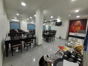 a dining room with tables and chairs and a screen at Hotel Aravali Hills View in Kuchāman City