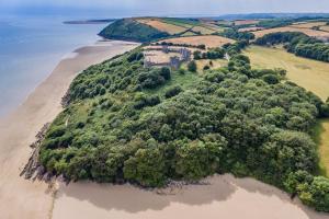 an island in the middle of a body of water at Llais Y Mor - large holiday home close to the beach - sleeps 8 in Carmarthen