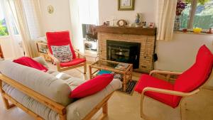 a living room with red chairs and a fireplace at Cedra 5, Holiday home, cosy apartment in Turre