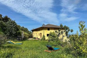 a yellow house in the middle of a field at Eco Gîte avec vue sur mer in Chiatra