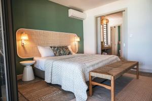 a bedroom with a bed and a bench in it at La Pépite Villa in Pointe d'Esny
