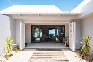 a white house with a patio with a view of the ocean at La Pépite Villa in Pointe d'Esny