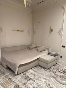a white bedroom with a large bed and a couch at Ivory 1831 Boutique Apartment Luxury bath in Chişinău