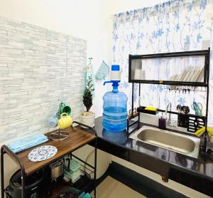 a kitchen counter with a sink and a bottle of water at LoveCo Vacation house close to Dahilayan with private parking in Manolo Fortich +10 photos