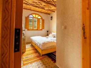 a bedroom with a bed and a window at Berber Surf House in Tamraght Ouzdar