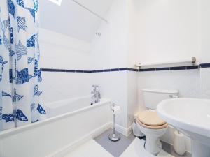 a white bathroom with a toilet and a sink at Carpenter's Cottage in Matlock +11 photos