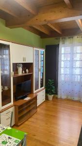 a living room with a tv on a wooden floor at Nido 33 in Ribadeo