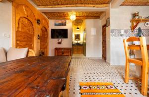 a living room with a wooden table in a room at Berber Surf House in Tamraght Ouzdar +110 photos