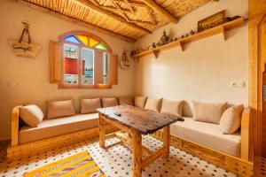 a living room with a couch and a table at Berber Surf House in Tamraght Ouzdar
