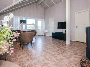 a living room with a table and chairs and a television at 5 star holiday home in Ringkøbing in Ringkøbing +37 photos